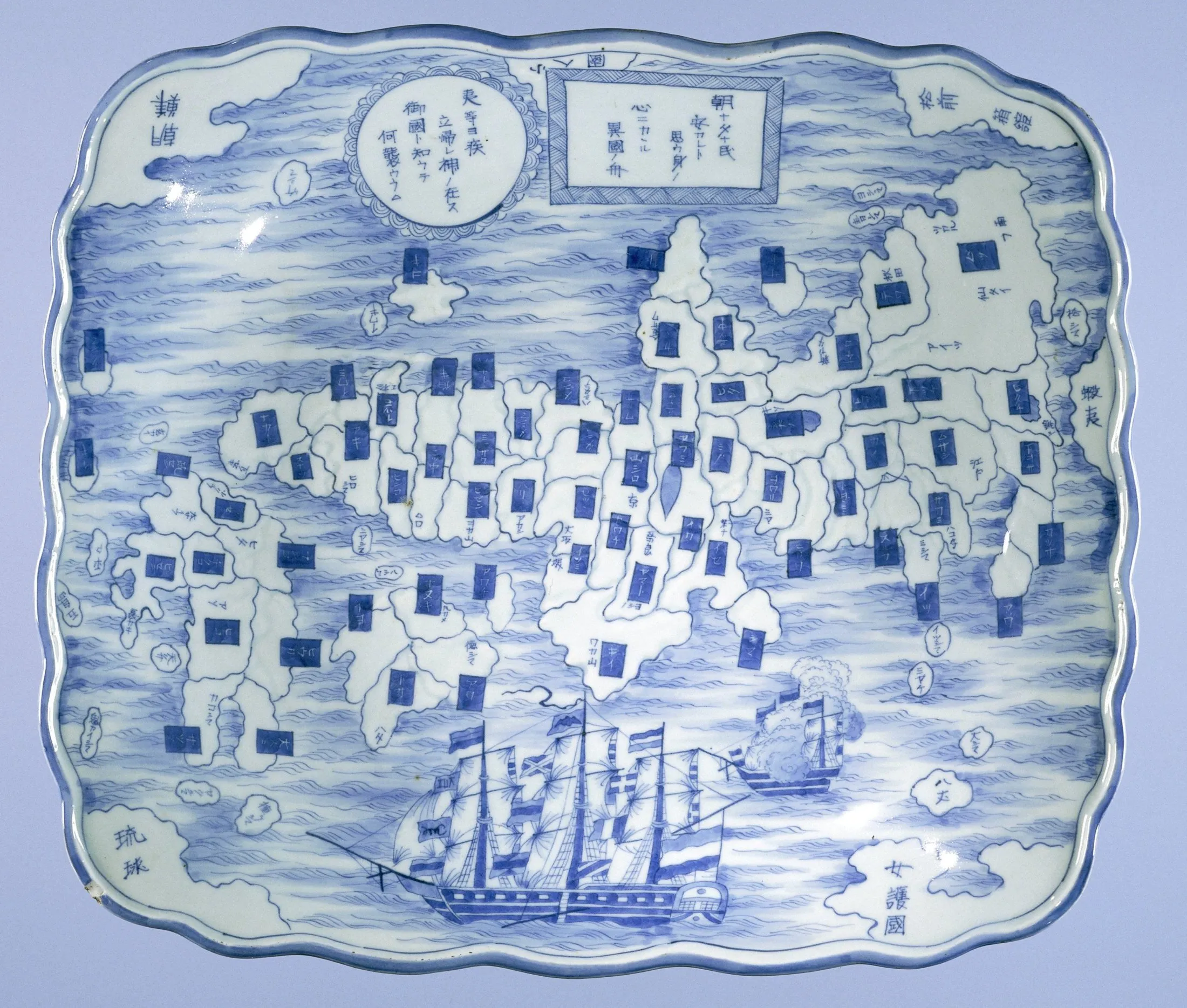 A blue-and-white porcelain platter is painted with a provincial map of Japan, Korea and the Ryukyu Islands, foreign ships, waves, and Japanese inscriptions.